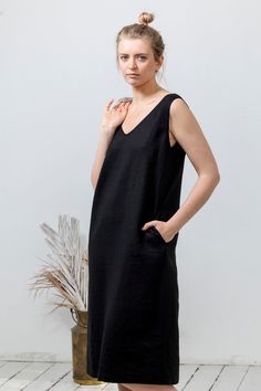 "- Sleeveless dress made of softened, dyed linen fabric. - V-neckline in front. - Open, V-shaped back. - Side pockets - Seam at the back. - Lower calf length. - Slightly A-line silhouette. - Relaxed fit. Our garments from linen fabric are designed in simple, relaxed design. Light, breezy and easy to wear. Perfect choice for summer. Linen fabric is breathable, sustainable and hypoallergenic. Medium weight 100% linen. High quality European linen (OEKO-TEX certified). Softened, dyed linen fabric. We strongly believe - the garment is finished only when a person wears it! Sizing: Model is 180 cm/5'9 tall and wears size M. Note: Since all of our garments are hand made and custom made for you, there could be 1-2 cm/0.4-0.8 in difference in measurements. Size S (US 2-6; UK 6-10; EU 34-38; AU 6-10) Unlined Linen V-neck Midi Dress, Black Linen V-neck Midi Dress, Black V-neck Linen Dress For Summer, Chic Black Linen V-neck Dress, Black Sleeveless Linen Dress, Chic Black V-neck Linen Dress, Linen Summer Dress, Sleeveless Linen Dress, Linen Tunic Dress