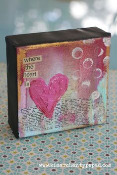 a close up of a small box with a pink heart on the front and words where the heart is