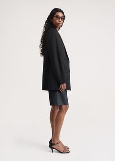 TOTEME blazer woven from recycled polyester and wool yarns to an oversized, double-breasted silhouette with a wide back and well-defined, padded shoulders, then finished with welt pockets and two back vents. Leave it open to show glimpses of the satin lining inside. Black Structured Blazer Dress For Office, Structured Black Blazer Dress For Office, Winter Blazer With Structured Shoulders, Chic Black Blazer With Structured Shoulders, Tailored Black Structured Blazer Dress, Black Blazer With Structured Shoulders For Fall, Black Structured Shoulder Blazer For Fall, Black Outerwear With Structured Shoulders For Evening, Oversized Structured Blazer For Business