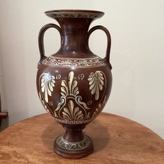 a brown vase sitting on top of a wooden table