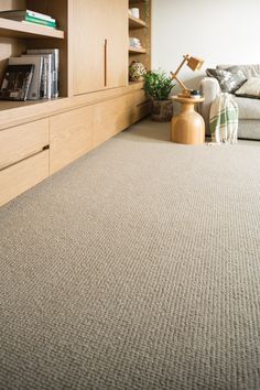 a living room scene with focus on the carpet and bookcase in the background,