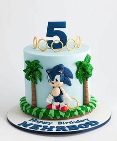 a blue and white birthday cake with sonic the hedgehog on top