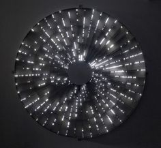 a circular mirror with lights in the shape of a starburst on it's side