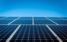 rows of solar panels against a blue sky