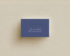 a blue business card sitting on top of a white surface with the words reverto printed on it