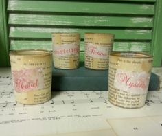 three jars with labels on them sitting on top of a sheet of paper next to a green wall