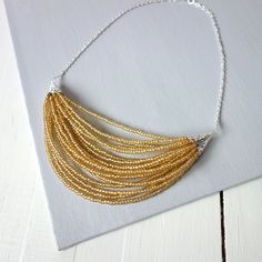 Elegant Yellow Beaded Chain Necklace, Gold Beaded Multi-strand Bib Necklace, Gold Beaded Chain Bib Necklace As Gift, Gold Beads With Silver Details As A Gift, Gold Beaded Necklaces For Jewelry Making, Elegant Yellow Beaded Necklaces With Tiny Beads, Gold Bib Necklace For Party, Gold Beaded Chain Bib Necklace For Party, Yellow Beaded Bib Necklaces With Round Beads