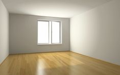 an empty room with hard wood floors and white walls