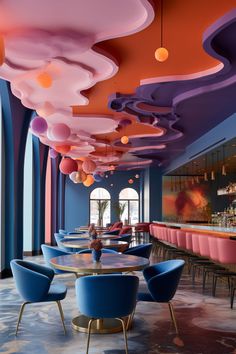 the interior of a restaurant with blue, pink and orange chairs on either side of the bar