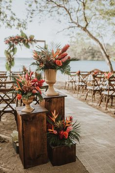 two vases filled with flowers sitting on top of wooden benches