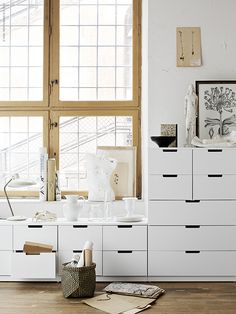 a white dresser sitting next to a window in a room