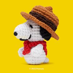 a crocheted dog with a hat and scarf on it's head is posed in front of a yellow background