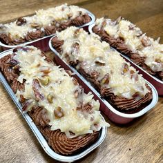 four tins filled with food sitting on top of a wooden table