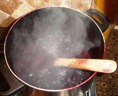 a pot on the stove with steam rising from it and a wooden spoon sticking out