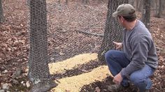 a man kneeling down next to a fence