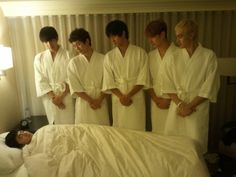 the boys are all dressed in white robes and posing for a photo on their bed