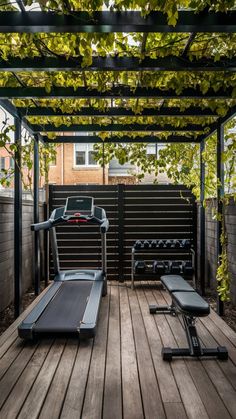 an outdoor gym with treadmills, exercise equipment and climbing vines on the roof