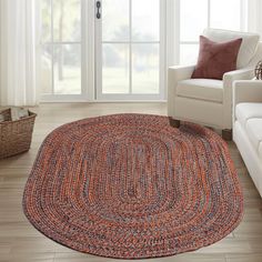 a living room with white couches and an orange rug