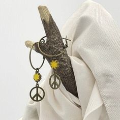 Unique bronze peace sign earrings. Fun, 70s style hippie earrings handmade with a yellow Czech glass flower bead. The dangle drop is made with a 15mm bronze peace sign and a 9mm yellow Czech glass flower bead with a Picasso edge. Casual everyday earrings. They are very lightweight, comfortable, and fun to wear. The bronze hoops are  1-inch in diameter (25mm), lead, and nickel-free with a lever back closure. The total earring length is 2 1/8 inches, measuring from the top of the hoop to the botto Bohemian 70s, Peace Sign Earrings, Earrings Boho Chic, Hoop Dangle Earrings, Dangle Earrings Boho, Hippie Earrings, Boho Chic Jewelry, 70s Style, Chic Jewelry