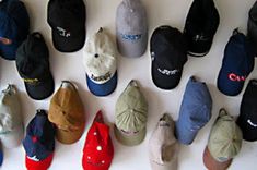 many hats are lined up on the wall