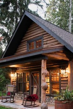 a log cabin with rocking chairs on the front porch and covered in wood shingles