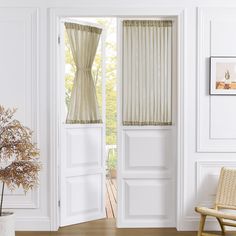 an open door with curtains and a chair in the room next to it on a hard wood floor