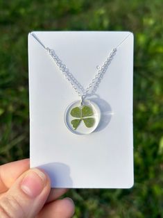 These Elegant Charmed Necklaces are Resin Poured with a Genuine 4 Leaf Clover placed inside. Makes for the perfect gift for any occasion! Each charm comes with a 20-inch silver chain.  **There are 6 Charmed Necklaces to choose from- Circle - length - 2cm, width - 2cm Teardrop - length - 3cm, width - 2cm Square - length - 2cm, width - 2cm Rectangle - length - 4cm, width - 1cm Guitar Pick 1(short) - length - 3cm, width - 2 1/2cm Guitar Pick 2(wide) - length - 3cm, width - 3cm Green Leaf-shaped Jewelry Gift, Green Round Necklaces With Pressed Flowers, Leaf Shaped Pressed Flowers Jewelry Gift, Leaf-shaped Pressed Flowers Jewelry Gift, Handmade Leaf-shaped Necklace Gift, Handmade Leaf-shaped Necklace For Gifts, Handmade Leaf Shaped Necklace For Gift, Handmade Leaf Necklace For Gift, Green Leaf-shaped Necklace For Gift