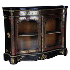 an ornately decorated wooden cabinet with glass doors