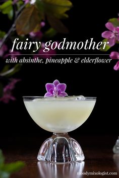 a glass bowl filled with white liquid and purple flowers