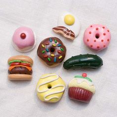 there are many different types of donuts on the white tablecloth, including one with frosting