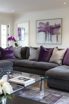 a living room filled with lots of furniture and flowers on top of a coffee table