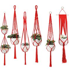 four hanging planters with plants in them, one is white and the other has red tassels