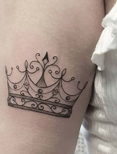 a woman's thigh with a crown tattoo on it