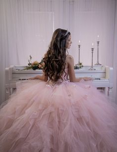 a woman in a pink dress sitting at a piano