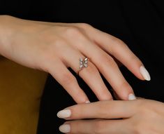 a woman's hand with white manicured nails and an engagement ring