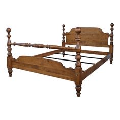 a wooden bed frame with posts and headboard