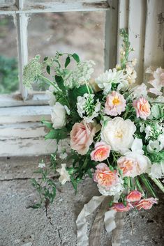 a bouquet of flowers sitting in front of a window