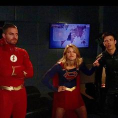 the flash and supergirls are standing in front of a tv