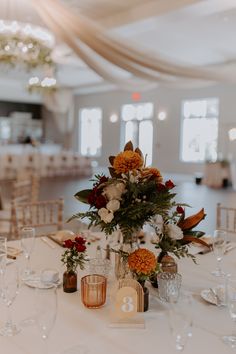 the table is set with flowers, candles and place settings for an elegant wedding reception