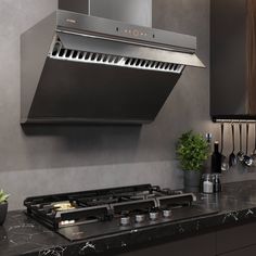 a modern kitchen with stainless steel appliances and black marble counter tops, along with hanging utensils