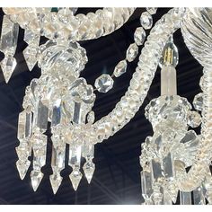 a chandelier hanging from the ceiling with crystal beads and chains on it's sides