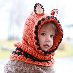 a little boy wearing a knitted hat and scarf with ears on it's head