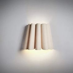 three wooden tubes are lit up on the wall