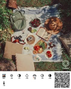 an open book sitting on top of a blanket next to a bag and some food