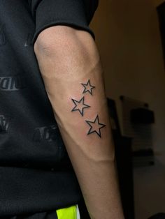 a man's arm with five stars tattooed on the left side of his arm