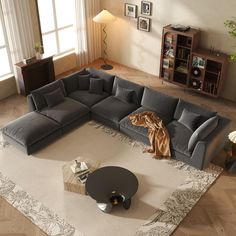 a large sectional couch sitting on top of a rug in a living room next to a window