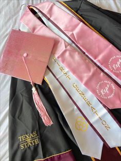 graduation caps and gowns laid out on top of each other with tassels