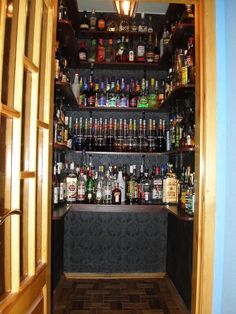 an open door leading to a bar with liquor bottles on the shelves and below it