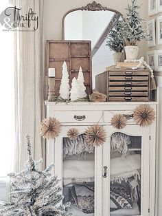 a white cabinet sitting next to a christmas tree