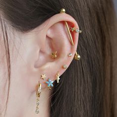 a woman's ear with three piercings on it